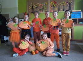 Uczniowie w pomarańczowych strojach.