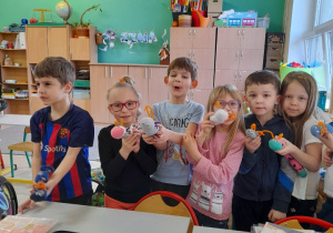 Uczniowie klasy 1b prezentują swoje prace ze skarpetek.