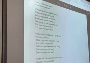 Zdjęcie tablicy multimedialnej z wyświetlonym fragmentem "Roty"