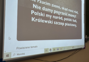 Zdjęcie tablicy multimedialnej z wyświetlonym fragmentem "Roty"