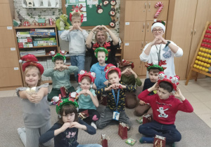 Dzieci wraz z prezentami przy choince.