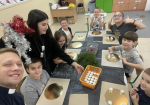 Uczniowie wraz z nauczycielką podczas tworzenia wieńców adwentowych.