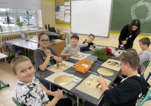 Uczniowie wraz z nauczycielką podczas tworzenia wieńców adwentowych.