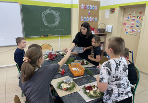 Uczniowie wraz z nauczycielką podczas tworzenia wieńców adwentowych.
