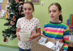 Uczennice roznoszące sianko pod obrus wigilijny.