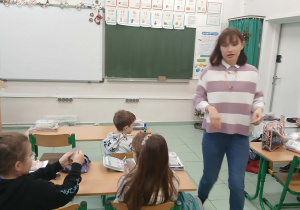 Uczniowie wraz z praktykantką podczas tworzenia eko domków.