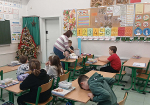 Uczniowie wraz z praktykantką podczas tworzenia eko domków.