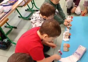 Uczniowie wraz z prowadzącą warsztaty podczas tworzenia dekoracji świątecznej.