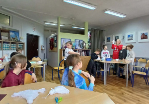 Uczniowie wraz z prowadzącą warsztaty podczas tworzenia aniołów z włóczki.