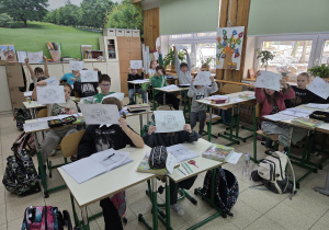 Uczniowie prezentujący karty pracy.