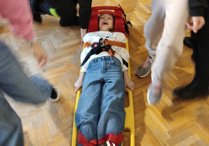 Uczennica leżąca na noszach do ewakuacji.