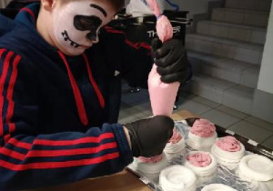 Uczeń podczas dekorowania ciastek.