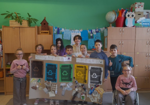 Uczniowie z plakatem dotyczącym prawidłowej segregacji śmieci.