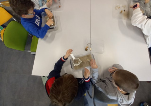 Uczniowie stosują sito by znaleźć drobne zabytki