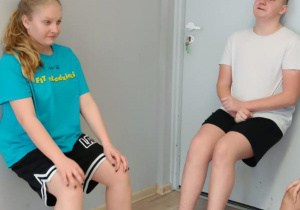 Uczniowie podczas wykonywania tzw. "krzesełka".