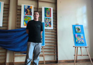 uczeń klasy 6 b na tle prac konkursowych