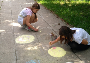 Rysowanie obrazków na ścieżce przez dziewczynki