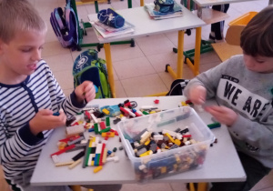 Uczniowie budują labirynt z małych klocków