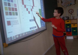 Uczeń rozkodowuje obrazek na tablicy multimedialnej