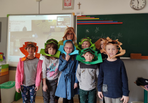 Dzieci z nauczycielem w zabawnych kapeluszach