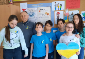 Uczniowie wraz z nauczycielem trzymają serce w barwach Ukrainy