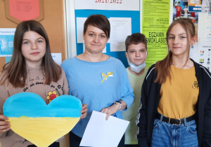 Uczniowie wraz z nauczycielem trzymają serce w barwach Ukrainy