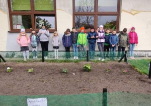 Zdjęcie uczniów w stworzonym przez nich ogródku szkolnym