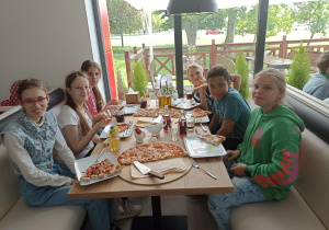 Uczniowie jedzący pizzę