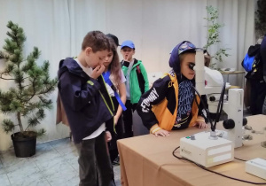 Dziecko korzysta z mikroskopu