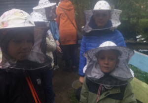 Uczniowie w kapeluszach pszczelarskich