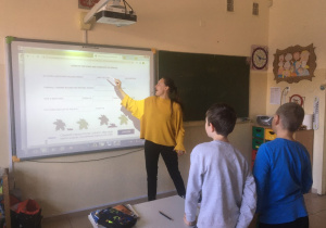 Nauczycielka uczy dzieci tekstu piosenki.