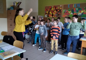 Uczniowie śpiewają i tańczą do piosenki.