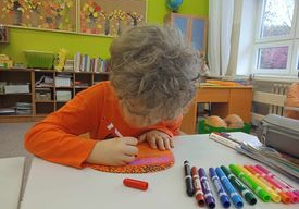 Chłopiec rysuje szlaczki na dyni.