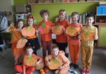 Uczniowie w pomarańczowych strojach.