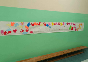 Plakat wywieszony na ścianie prezentujący napis Dzień Tolerancji oraz przyklejone kolorowe dłonie.
