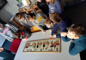 Grupa uczniów słuchająca wykładu, na stole 100-letnia kodra - wycinanka łowicka