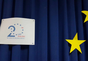 Plakat 20 lat Polski w UE na granatowym tle z dwiema żółtymi gwiazdami
