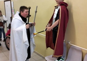 Wręczanie królowi dwóch mieczy przez rycerza zakonu - przebrani uczniowie