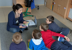 Nauczycielka wraz z uczniami podczas czytania wierszyka o kotku Amadeuszu.