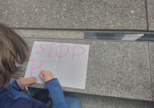 Uczennica tworząca plakat mający na celu na celu przeciwdziałanie zjawisku nietolerancji i dyskryminacji.