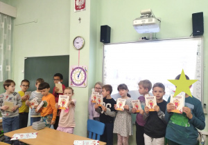 dzieci na tle tablicy z książkami
