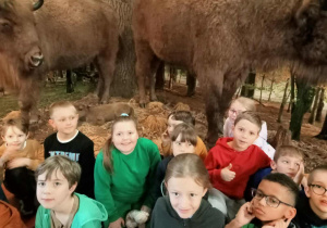 Na zdjęciu dziewczynki stojące na tle wypchanych żubrów.